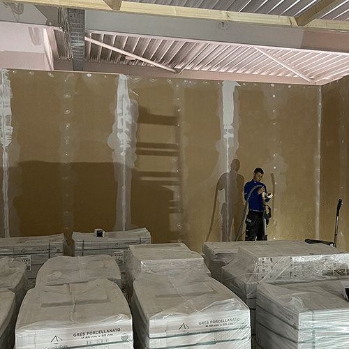 Trockenbau-Innenausbau durch interactive Studio: Mitarbeiter montiert Gipskartonplatten für gewerblichen Innenausbau in Freizeit- oder Industrieanlage